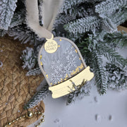 Decorative ornament with gold accents hanging on a Christmas tree.