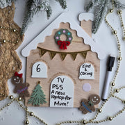 Decorative gingerbread house-shaped board with Christmas elements on a white background
